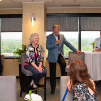 tom and marcia in middle of room addressing crowd